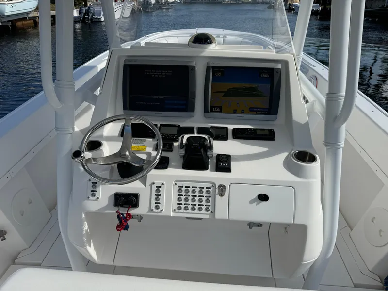 Slide: The Image of 2014 Intrepid 327 Center Console boat dashboard with dual screens and steering wheel. - 20