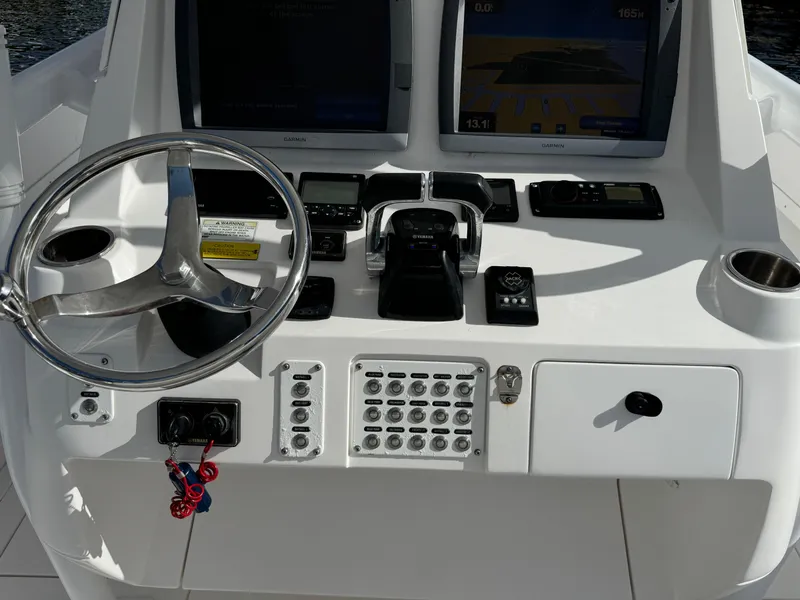 Slide: The Image of 2014 Intrepid 327 Center Console boat dashboard with steering wheel and navigation controls. - 9