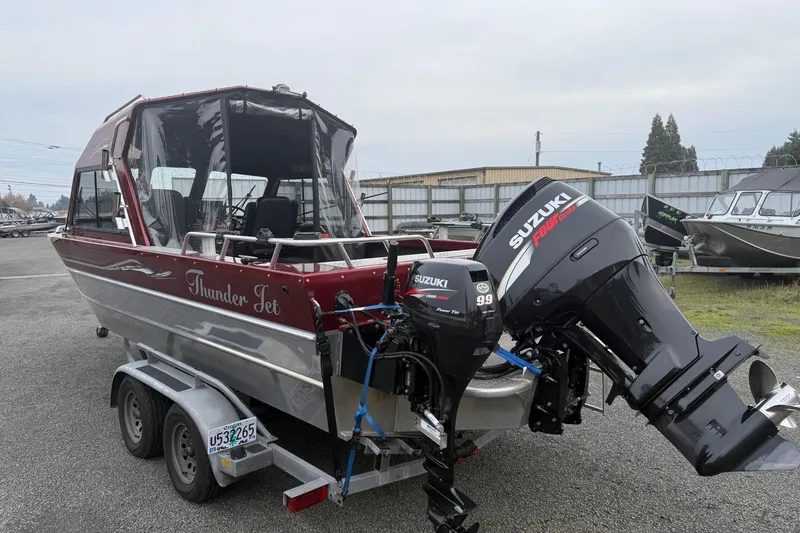 Slide: The Image of 2010 Thunder Jet 21 Luxor OB boat on trailer, red and silver design, parked outdoors. - 4