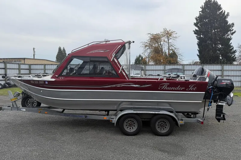 Slide: The Image of 2010 Thunder Jet 21 Luxor OB boat on trailer, parked outdoors. - 5