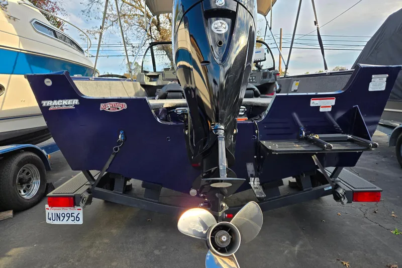 Slide: The Image of 2021 Tracker Pro Guide V-175 Combo boat, rear view with motor and trailer. - 95