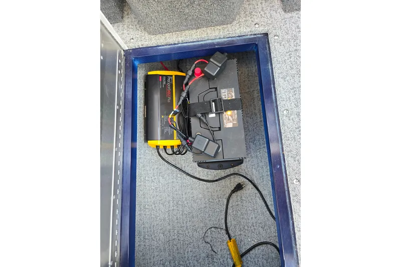 Slide: The Image of Battery compartment of 2021 Tracker Pro Guide V-175 Combo boat, featuring a ProMariner charger. - 96