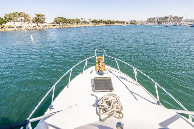 Slide: The Image of Bow view of 1987 Blackfin 32 Flybridge on calm waters near shoreline. - 11