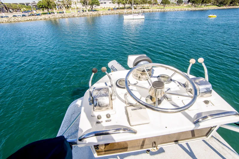Slide: The Image of 1987 Blackfin 32 Flybridge helm with steering wheel, controls, and water view. - 12