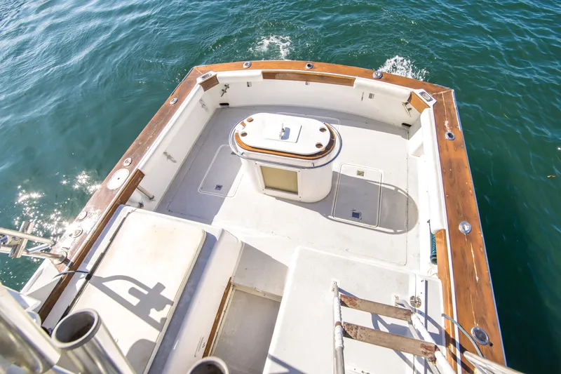 Slide: The Image of 1987 Blackfin 32 Flybridge boat deck with wooden trim, overlooking sparkling blue water. - 13