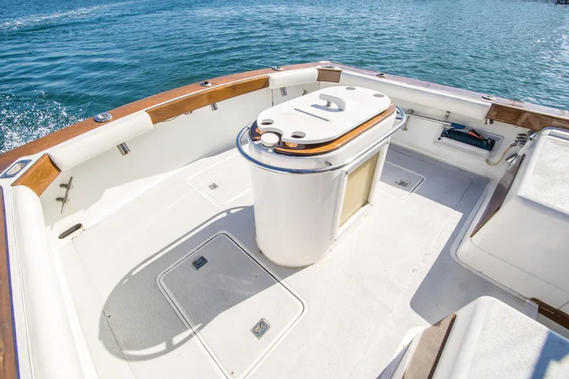 Slide: The Image of 1987 Blackfin 32 Flybridge boat deck with storage, surrounded by calm blue water. - 15