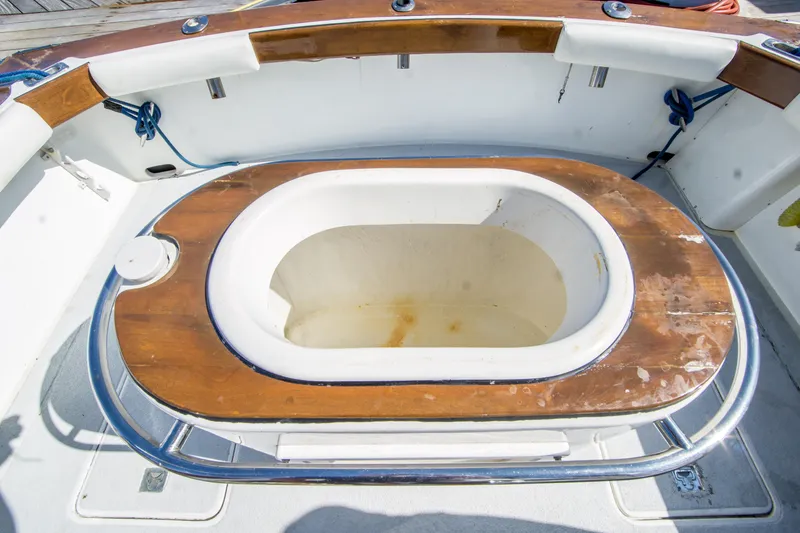 Slide: The Image of 1987 Blackfin 32 Flybridge boat deck with wooden trim and built-in storage compartment. - 18
