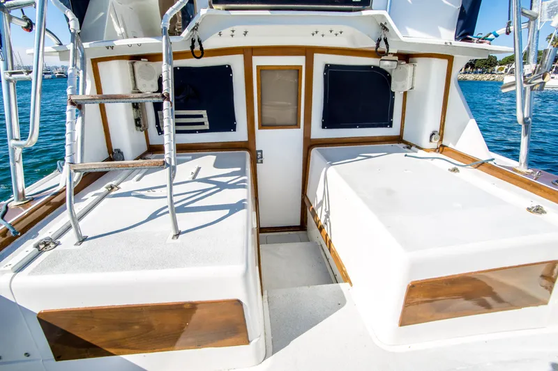 Slide: The Image of 1987 Blackfin 32 Flybridge boat deck with ladder and seating, docked on calm water. - 19