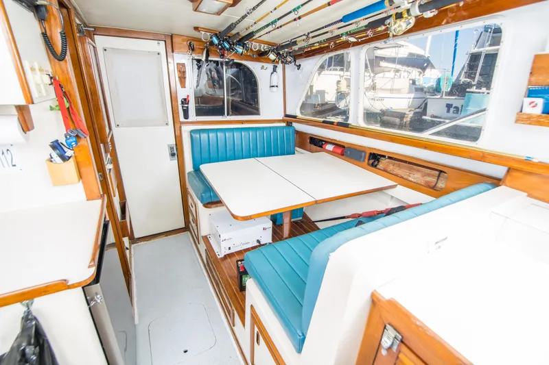 Slide: The Image of Interior of 1987 Blackfin 32 Flybridge with blue seating and fishing rods. - 22