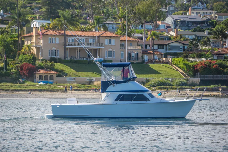 Slide: The Image of 1987 Blackfin 32 Flybridge yacht cruising near luxurious waterfront homes. - 39