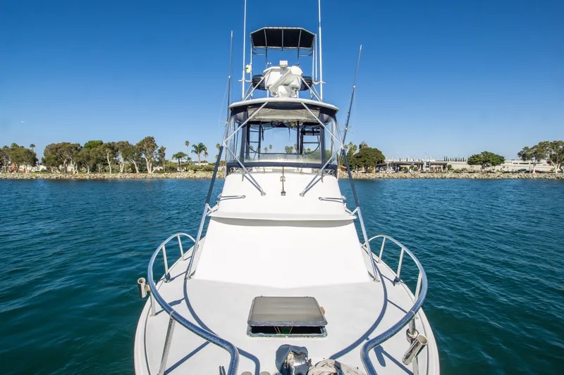 Slide: The Image of 1987 Blackfin 32 Flybridge boat on calm water, clear sky, coastal background. - 7