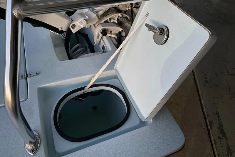 Slide: The Image of 2005 Hell's Bay Devilray boat with open storage compartment and visible engine components. - 15