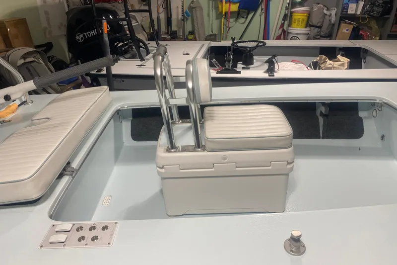 Slide: The Image of 2005 Hell's Bay Devilray boat interior with seating and storage in a garage. - 17