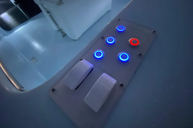 Slide: The Image of Control panel with illuminated buttons on a 2005 Hell's Bay Devilray boat. - 18