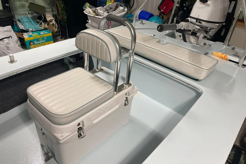 Slide: The Image of 2005 Hell's Bay Devilray boat interior with white cushioned seating and storage. - 19