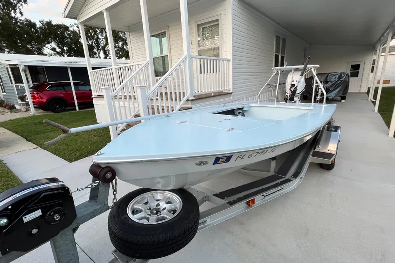 Slide: The Image of 2005 Hell's Bay Devilray boat on trailer, parked beside a house. - 5