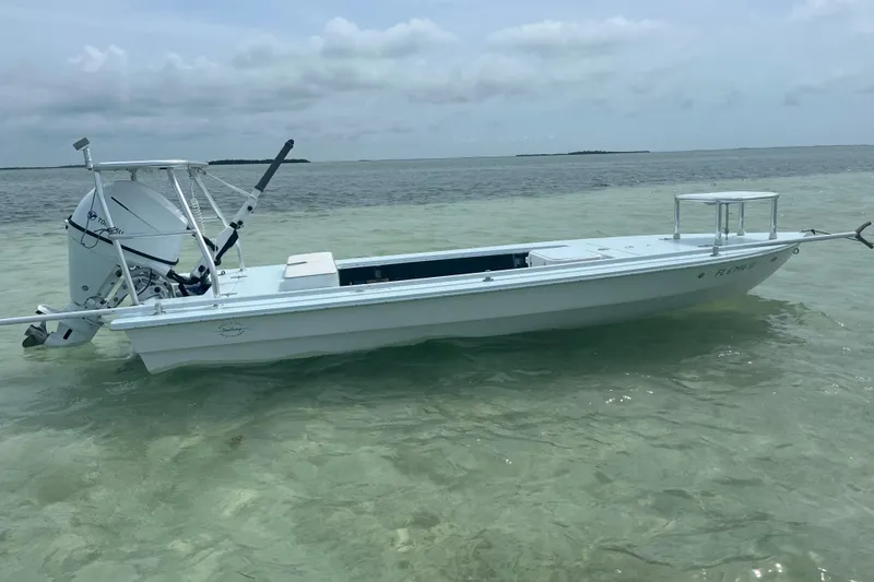 Slide: The Image of 2005 Hell's Bay Devilray boat in shallow, clear water with distant islands. - 6