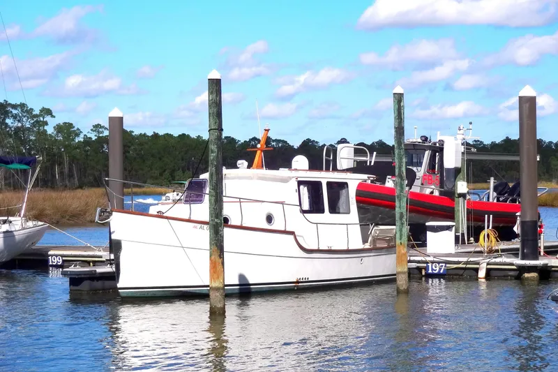 The Image of 2016 North Aegean Trawler 30 docked at a marina under a clear blue sky. - 1
