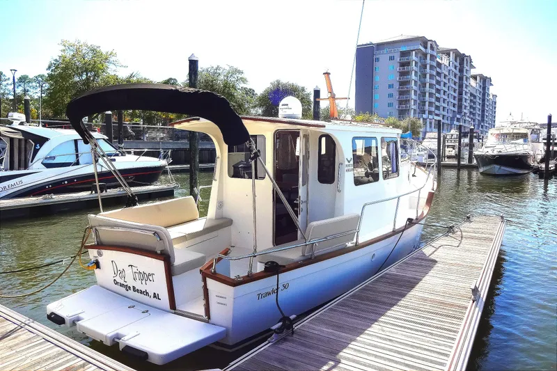 Slide: The Image of 2016 North Aegean Trawler 30 docked at marina, surrounded by modern buildings. - 10