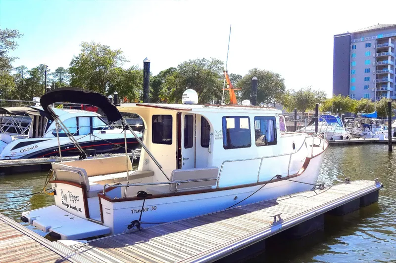 Slide: The Image of 2016 North Aegean Trawler 30 docked at marina, surrounded by boats and buildings. - 11