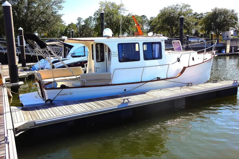 Slide: The Image of 2016 North Aegean Trawler 30 docked at marina, surrounded by trees and water. - 13