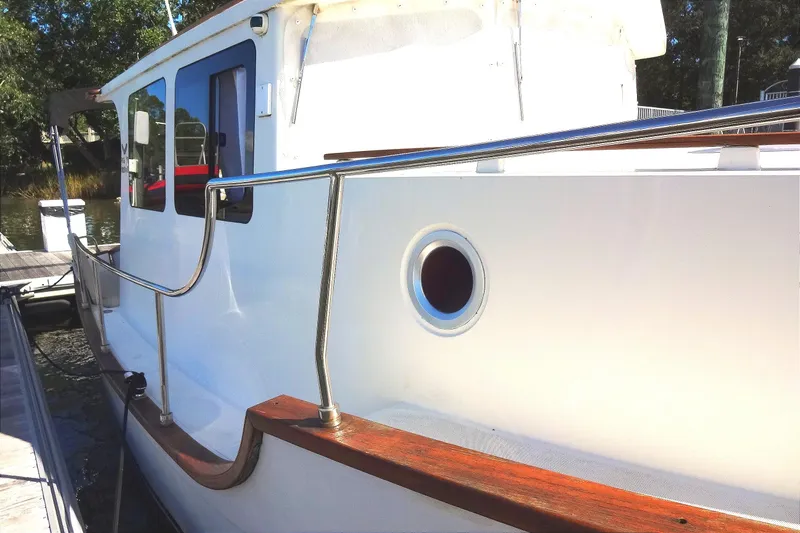 Slide: The Image of 2016 North Aegean Trawler 30 docked, showcasing sleek white exterior and porthole. - 15