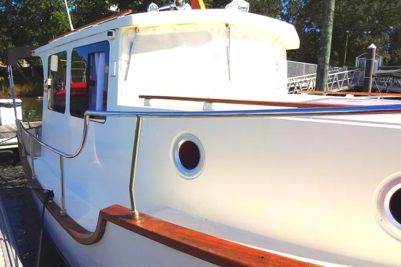 Slide: The Image of 2016 North Aegean Trawler 30 docked, showcasing sleek design and polished wood accents. - 16