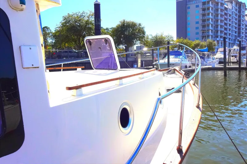 Slide: The Image of 2016 North Aegean Trawler 30 docked at marina, surrounded by boats and buildings. - 17
