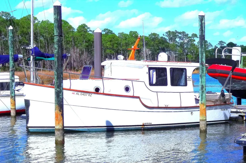Slide: The Image of 2016 North Aegean Trawler 30 docked in a serene marina setting. - 3