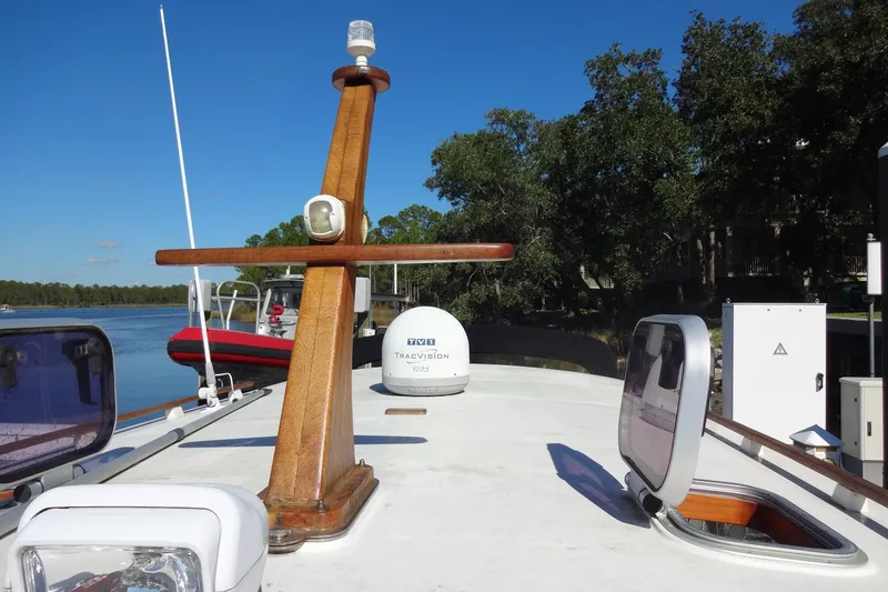 Slide: The Image of North Aegean Trawler 30, 2016 model, docked by a serene river with clear skies. - 30
