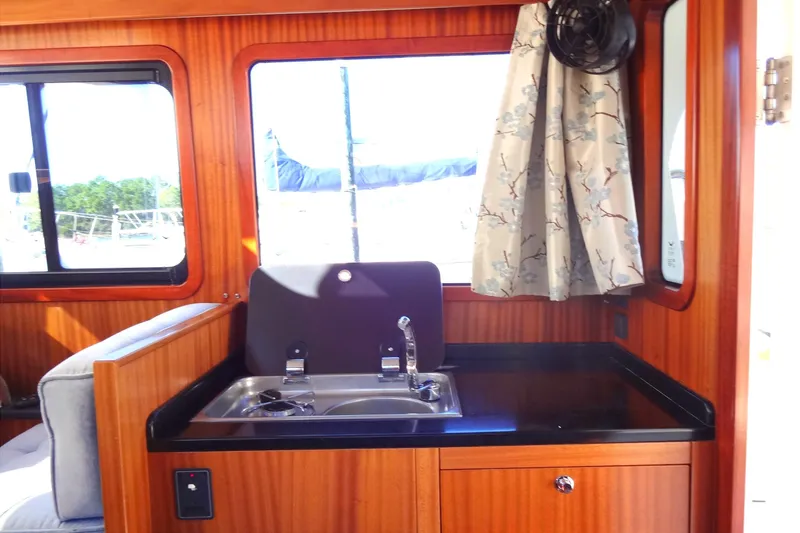Slide: The Image of Interior of 2016 North Aegean Trawler 30 with wooden cabinetry and compact sink. - 32