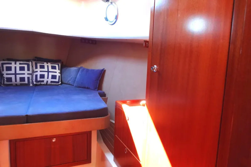 Slide: The Image of Cozy cabin interior of 2016 North Aegean Trawler 30 with blue bedding and wooden cabinetry. - 37