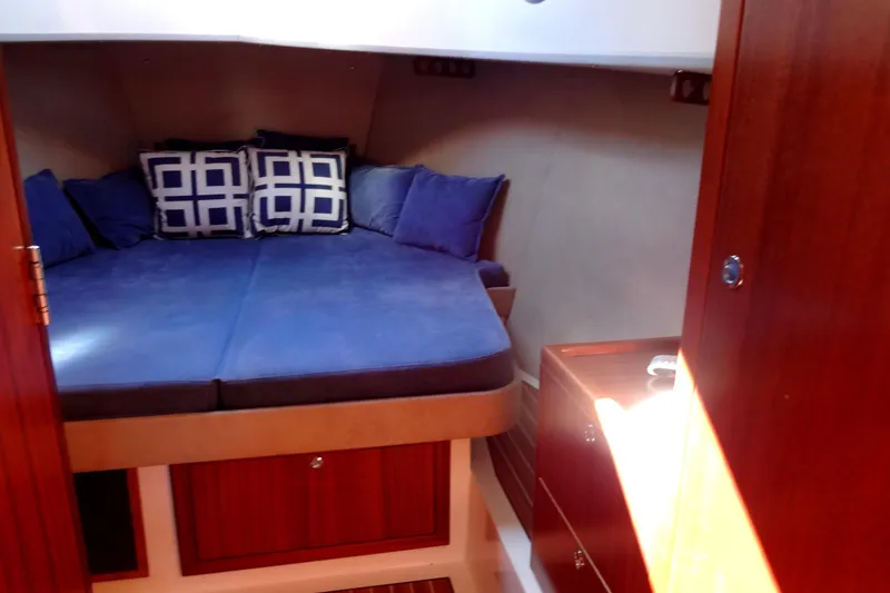 Slide: The Image of Cozy cabin interior of 2016 North Aegean Trawler 30 with blue bedding and wooden accents. - 40