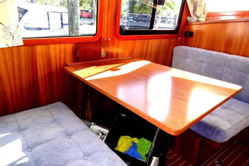 Slide: The Image of Cozy dining area inside 2016 North Aegean Trawler 30 with wooden table and cushioned seats. - 46
