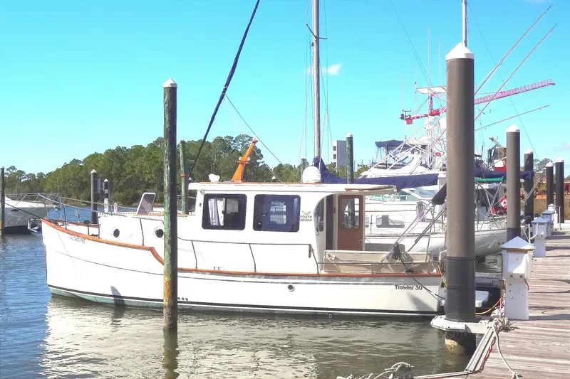 Slide: The Image of 2016 North Aegean Trawler 30 docked at marina under clear blue sky. - 6