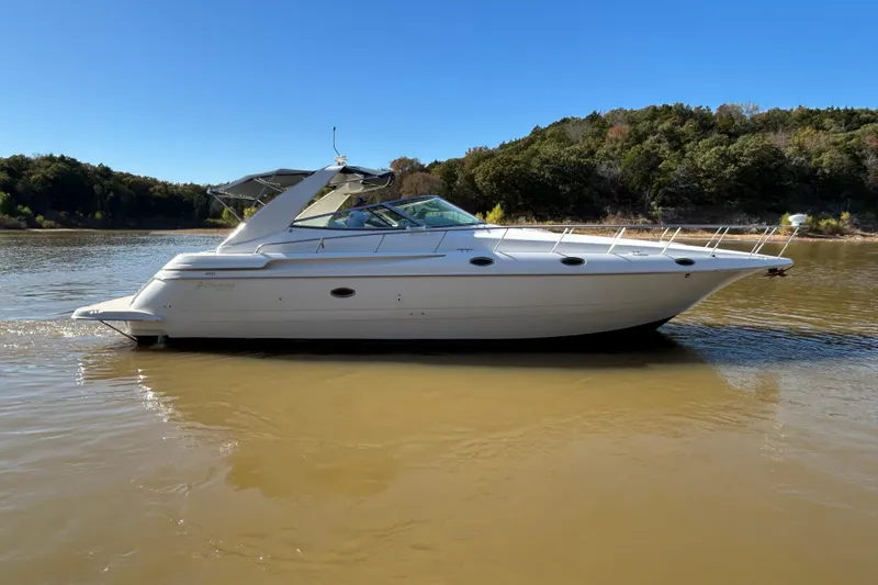 The Image of 1997 Cruisers 4270 yacht on calm river with forested background. - 1