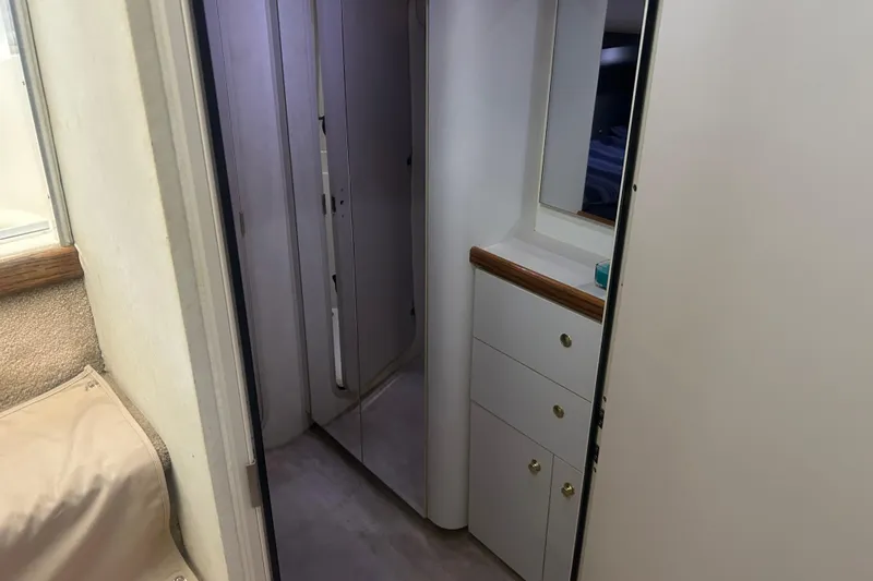 Slide: The Image of Interior of 1997 Cruisers 4270 yacht, featuring hallway with cabinets and mirror. - 26