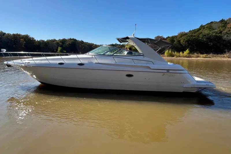 Slide: The Image of 1997 Cruisers 4270 yacht on calm water, surrounded by lush greenery. - 37