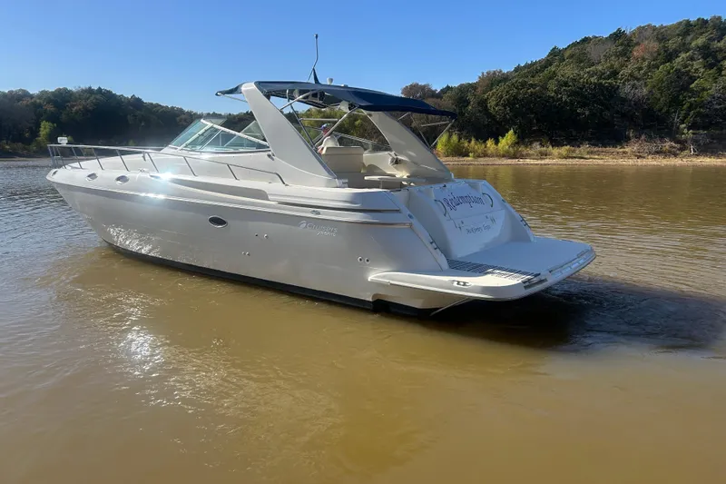 Slide: The Image of 1997 Cruisers 4270 yacht on calm water, surrounded by lush greenery. - 41