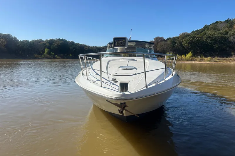 Slide: The Image of 1997 Cruisers 4270 yacht on calm river with forested background. - 13