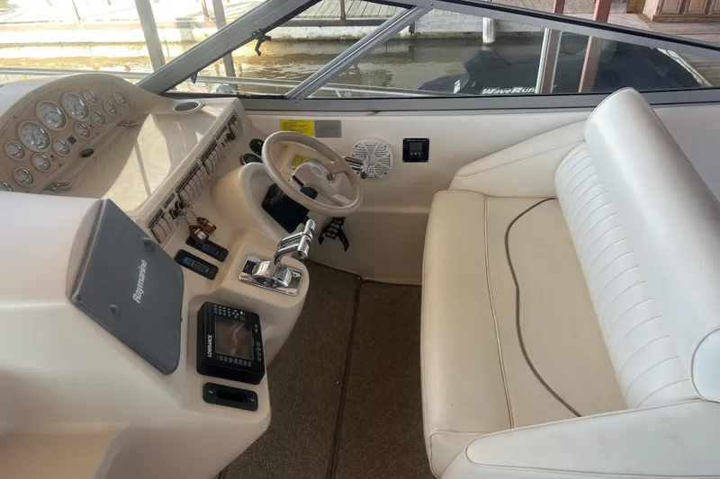 Slide: The Image of 1997 Cruisers 4270 boat cockpit with steering wheel, gauges, and white seating. - 18