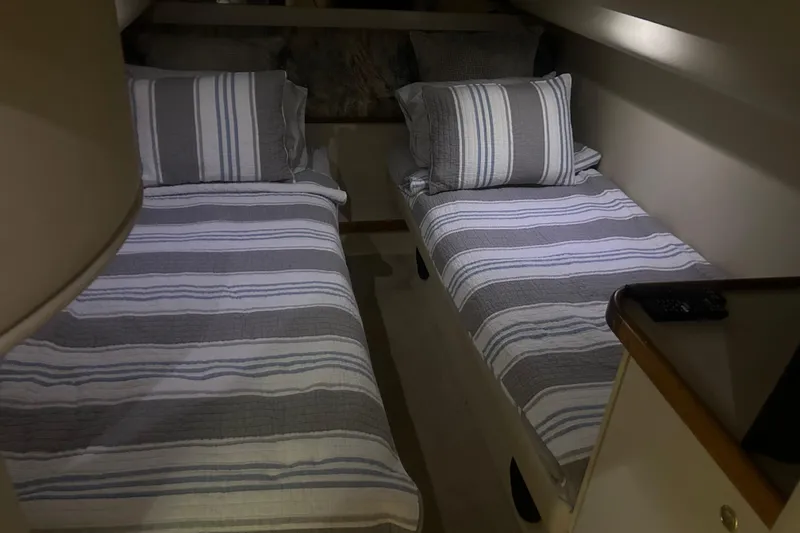 Slide: The Image of Twin beds with striped bedding in a 1997 Cruisers 4270 yacht cabin. - 28