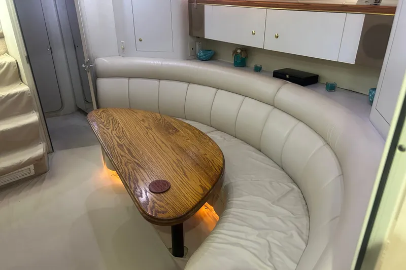 Slide: The Image of Luxurious 1997 Cruisers 4270 yacht interior with curved seating and wooden table. - 33