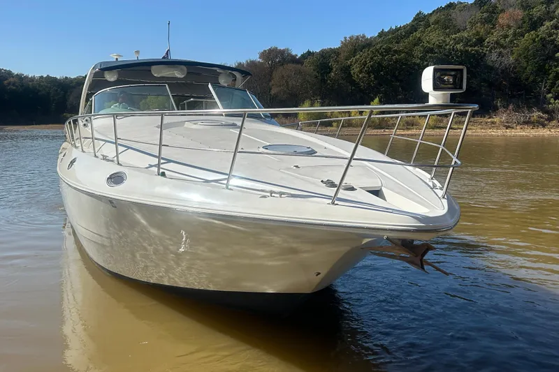 Slide: The Image of 1997 Cruisers 4270 yacht on calm water, surrounded by lush greenery. - 5