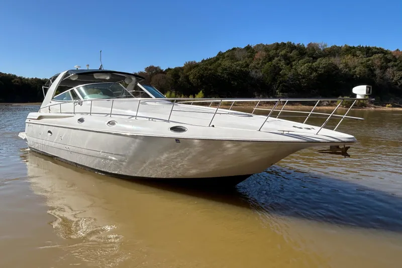 Slide: The Image of 1997 Cruisers 4270 yacht on calm water with forested background. - 7
