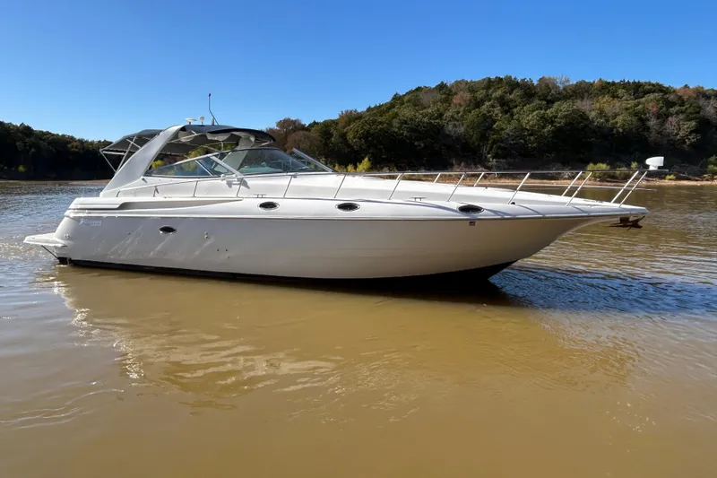 Slide: The Image of 1997 Cruisers 4270 yacht on calm water with forested shoreline. - 9