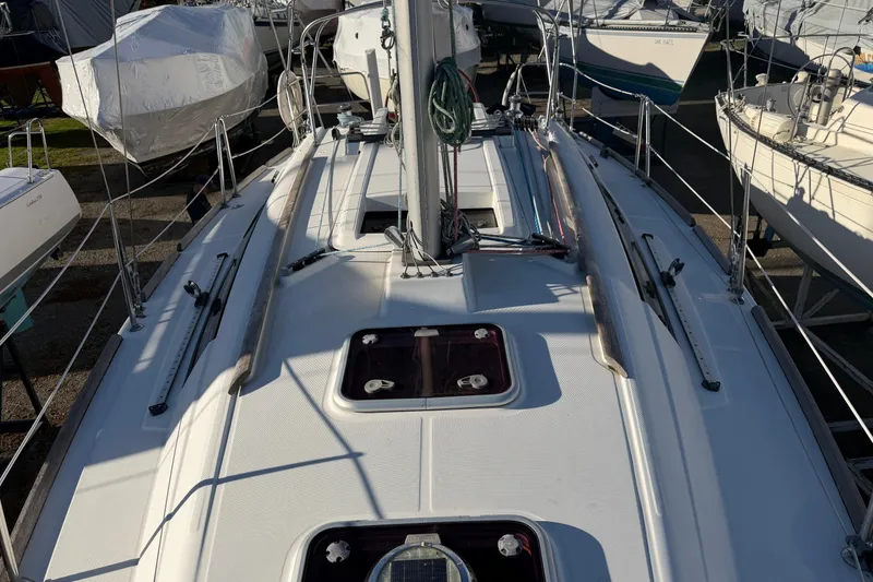Slide: The Image of 2008 Beneteau 31 sailboat deck view, showcasing rigging and hatches. - 25