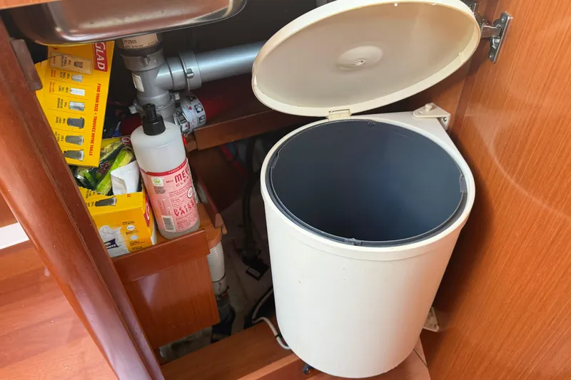 Slide: The Image of Under-sink storage on a 2008 Beneteau 31 yacht with trash bin and cleaning supplies. - 36