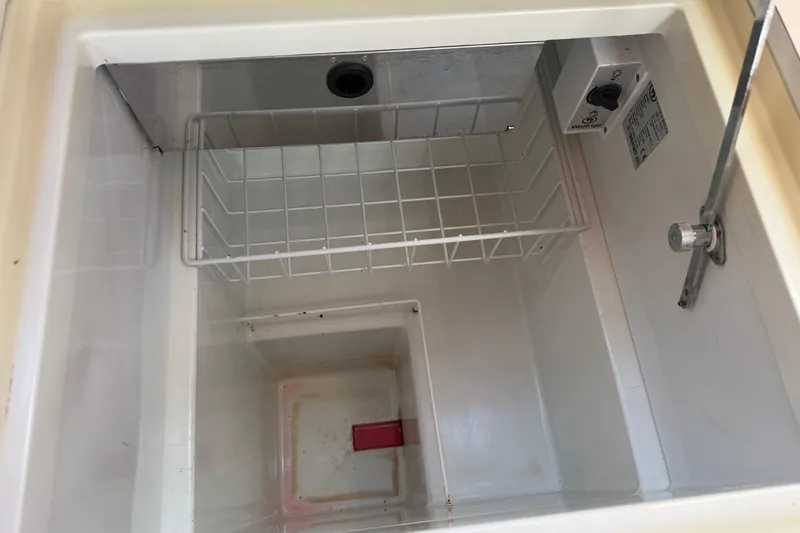 Slide: The Image of Empty refrigerator compartment in a 2008 Beneteau 31 boat, featuring a wire shelf. - 37