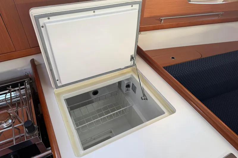 Slide: The Image of Open storage compartment in 2008 Beneteau 31 yacht interior, featuring wooden and upholstered finishes. - 38